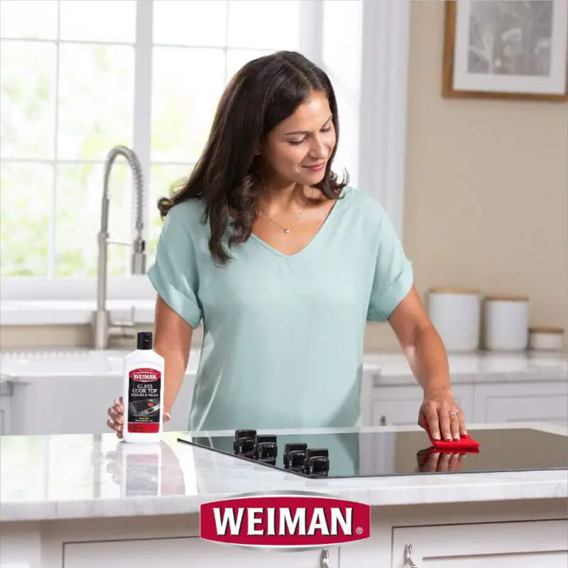 A Women Cleaning stove top with Weiman Best glass cooktop cleaner